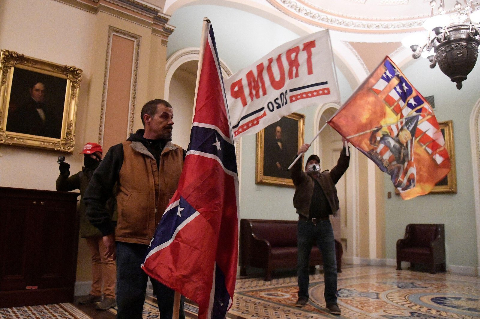 2E2ARNH A man carries a Confederate flag after supporters of President Donald Trump occupied the U.S. Capitol in Washington, U.S., January 6, 2021. Picture taken January 6, 2021.    REUTERS/Mike Theiler